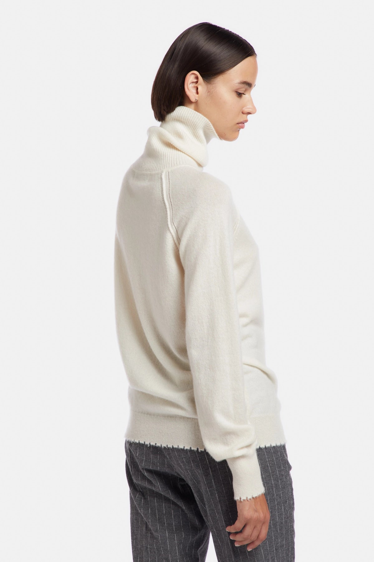 High neck sweater with tears at the bottom and cuffs