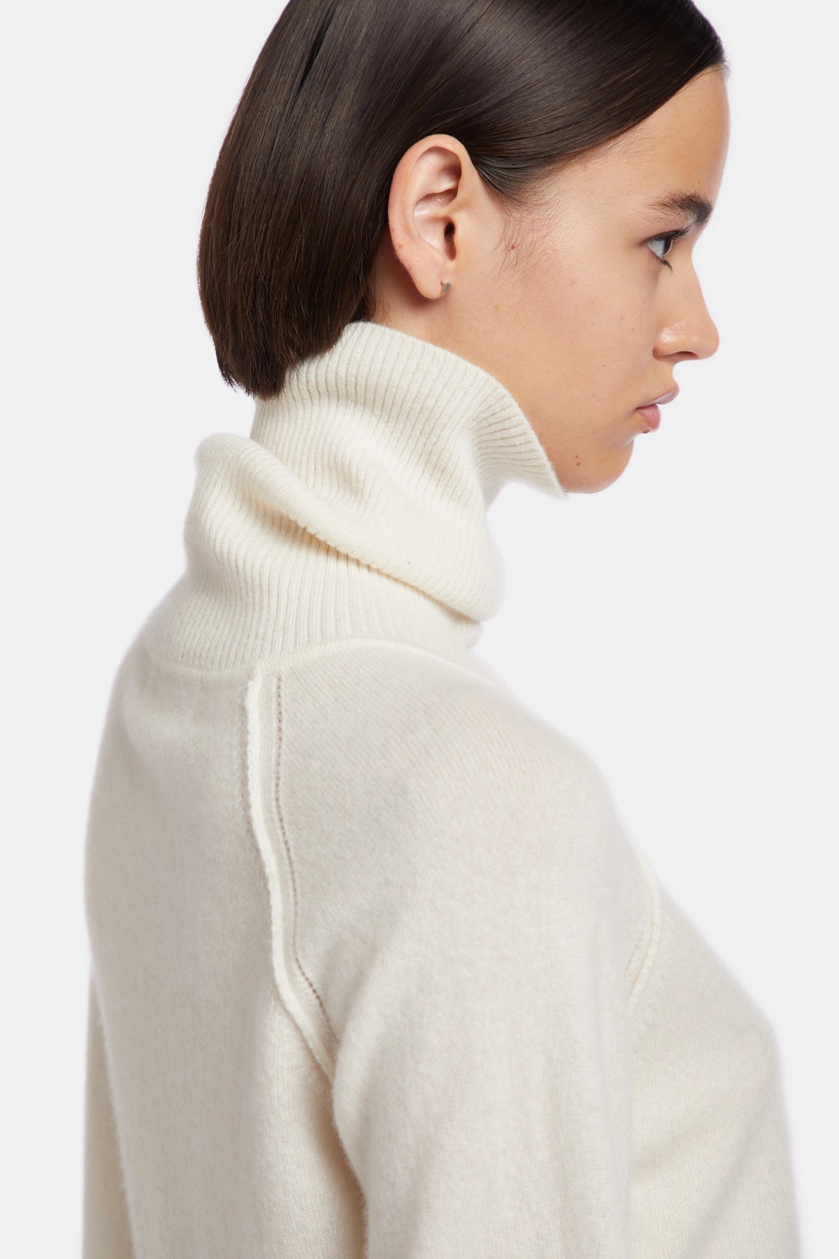 High neck sweater with tears at the bottom and cuffs